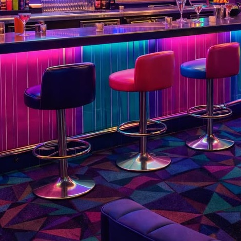 Neon-lit bar counter with colourful stools